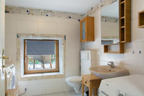 łazienka z umywalką, toaletą i oknem w obiekcie Landhaus am Eselhof Daxstein w mieście Schöllnach