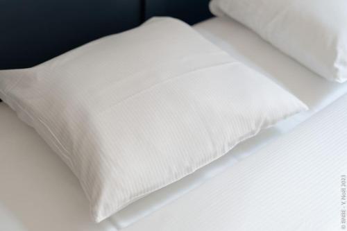 a white pillow sitting on top of a bed at Petite Dinant - Feet in water hands on the rock in Dinant