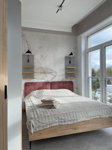 una camera da letto con un letto grande e una finestra di Tymiankowa Przystań a Ełk