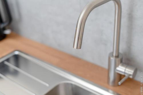 a kitchen sink with two faucets on a counter at Petite Dinant - Feet in water hands on the rock in Dinant