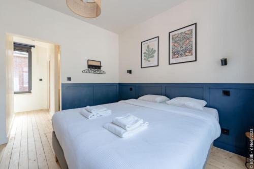 a large white bed with two white towels on it at Petite Dinant - Feet in water hands on the rock in Dinant