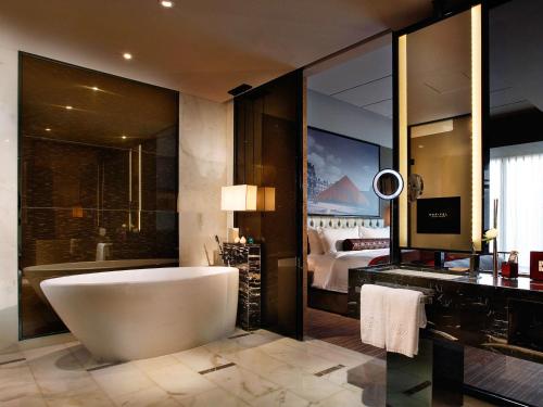 1 dormitorio y baño con bañera. en Sofitel Guangzhou Sunrich, en Guangzhou