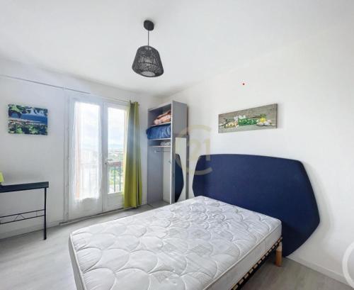 sypialnia z niebieskim łóżkiem i oknem w obiekcie T2 30m2 au calme, Vue montagnes, aperçu mer w Perpignanie