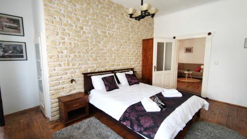 a bedroom with two beds and a brick wall at Casa Romana in Turda