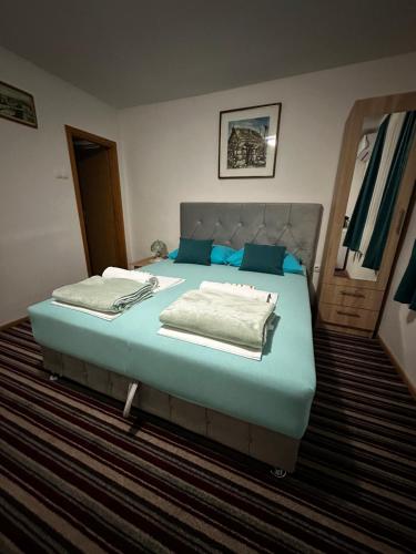 a bedroom with a large bed with blue sheets at Guest House Nana in Mostar