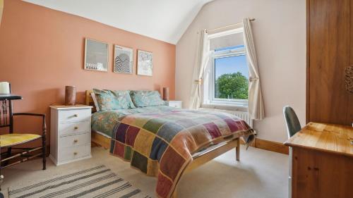 a bedroom with a bed and a window at Tranquil countryside cottage for two in Wrexham