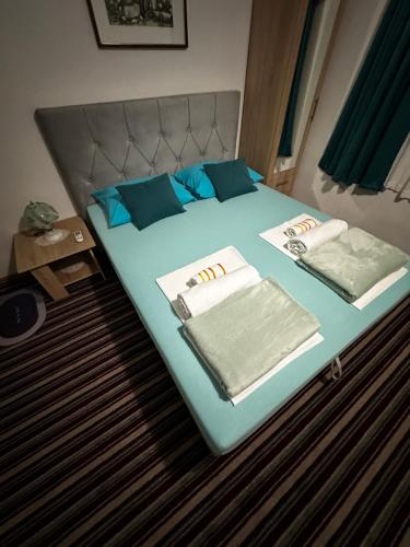 a bed with two pillows and towels on it at Guest House Nana in Mostar