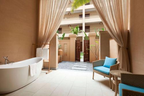 a bathroom with a tub and a chair and a building at Wyndham Maoming in Maoming