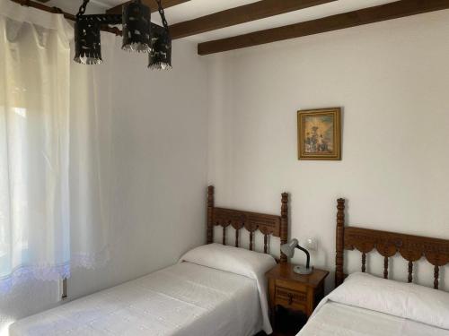 une chambre avec deux lits et une fenêtre dans l'établissement Apartamentos La Portilla de El Tejo, à El Tejo