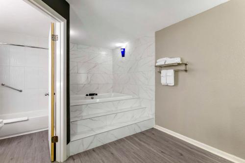 a bathroom with a tub and a shower stall at Quality Inn Gainesville near University in Gainesville
