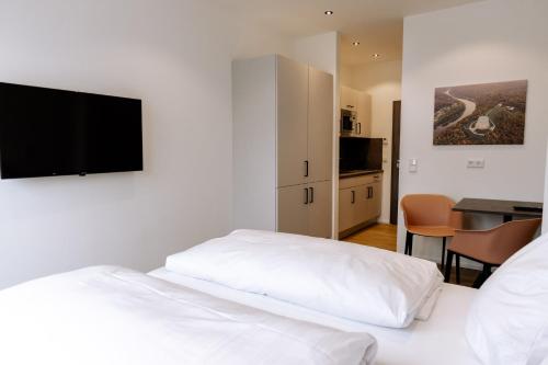 a hotel room with a bed and a flat screen tv at Heufeldboardinghouse in Kelheim