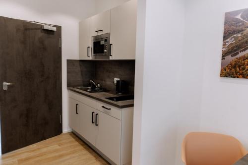 a small kitchen with a sink and a microwave at Heufeldboardinghouse in Kelheim