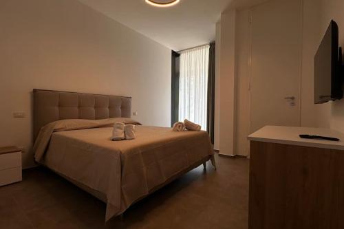 ein Schlafzimmer mit einem großen Bett mit Schuhen drauf in der Unterkunft CconfortHotels Puglia Promenade Apartment 2 in Bari