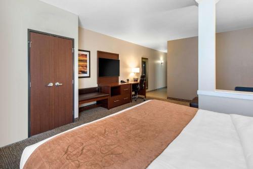 a hotel room with a large bed and a desk at Comfort Suites Denver International Airport in Denver