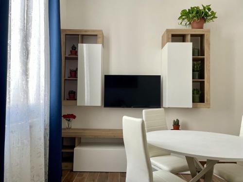 a dining room with a table and a tv at Casa Curcio in Bologna