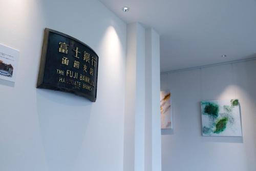 a sign hanging on a wall in a room at HakoBA Hakodate by THE SHARE HOTELS in Hakodate