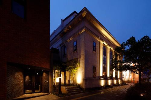 a building with lights on the side of it at night at HakoBA Hakodate by THE SHARE HOTELS in Hakodate