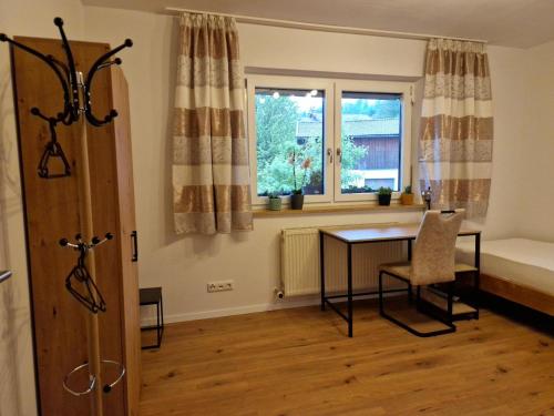 a room with a table and a bed and a window at Bachoase Bischofsmais in Bischofsmais