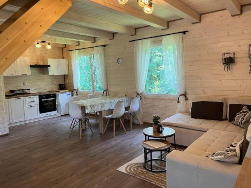 a kitchen and living room with a table and a couch at Domek wakacyjny Wczasy jak Marzenie in Ruciane-Nida