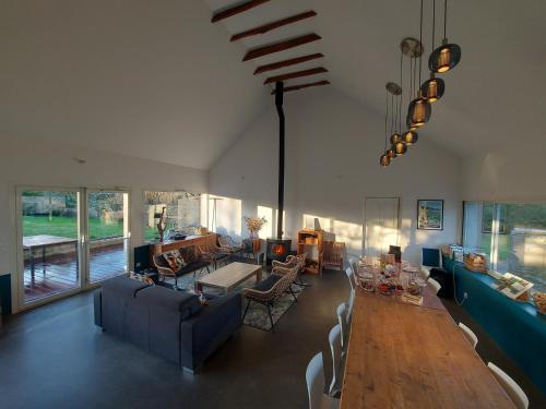 Cléden-Cap-SizunにあるLe quartier d'hiver, maison d'hôtesのテーブルと椅子のある広いリビングルーム