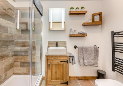 een badkamer met een wastafel en een douche bij Place Farm Cabin in Okehampton