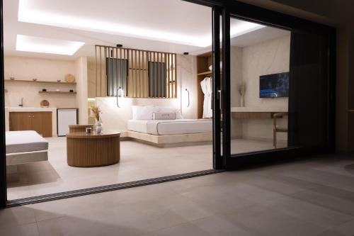 a living room with a couch and a living room with a window at Pnoe Luxury Suites in Fira