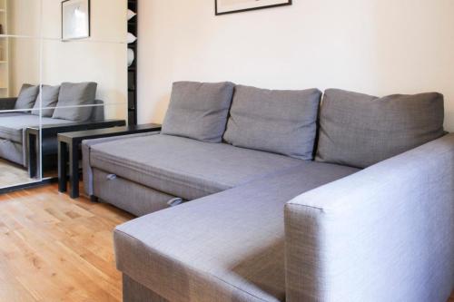 un salon avec un canapé et une chaise dans l'établissement Charming studio near Paris, à Saint-Ouen