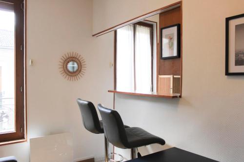 - une salle d'attente avec 2 chaises et un miroir dans l'établissement Charming studio near Paris, à Saint-Ouen