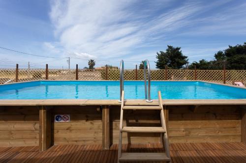 a chair sitting in front of a swimming pool at Dreamy Apartment with Veranda, Pool and Parking in Rilievo