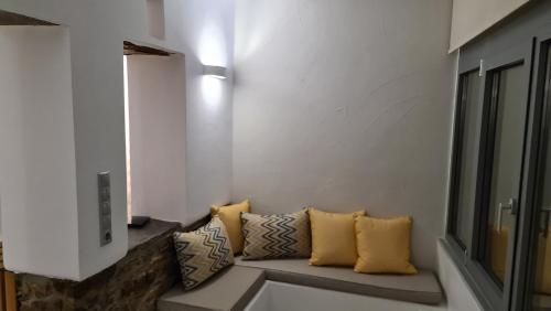 a living room with a couch with yellow pillows at Aegean Sunset in Agios Sostis