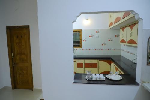 a kitchen with a mirror on the wall at Nanda Mohan Homestay- Luxury AC Apartment close to Alipiri Kapila Teertha and ISKON temples in Tirupati