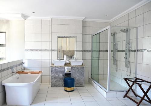 a bathroom with two sinks and a tub and a shower at Omni The Pillar Boutique Hotel in Bloemfontein