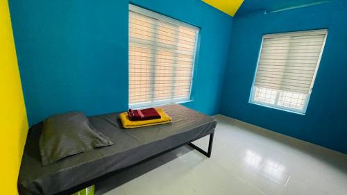 a room with a bed with blue walls and windows at Night Space hostel in Kalpetta