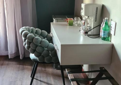 a chair sitting next to a desk with a mixer at Omni The Pillar Boutique Hotel in Bloemfontein