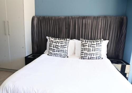a bedroom with a large bed with white sheets and pillows at Omni The Pillar Boutique Hotel in Bloemfontein