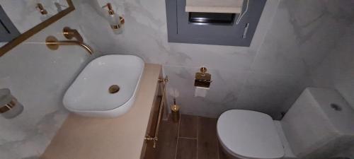 a bathroom with a white toilet and a sink at Aegean Sunset in Agios Sostis