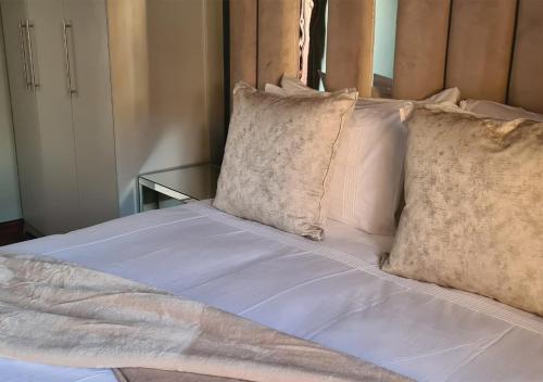 a bed with white sheets and pillows at Omni The Pillar Boutique Hotel in Bloemfontein