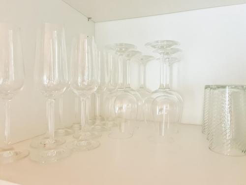 a row of wine glasses sitting on a white wall at Abendberg - zentral nähe Bahnhof in Wilderswil