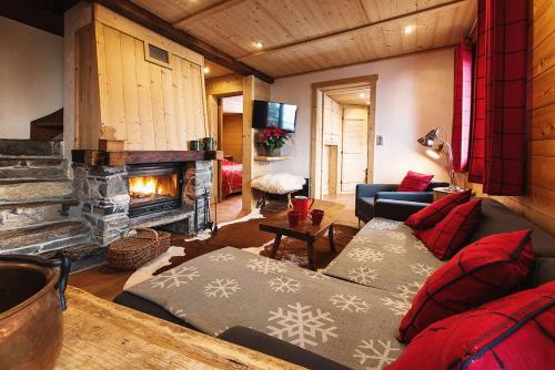 a living room with a couch and a fireplace at Les Chalets-Hôtel de la Croix-Fry in Manigod