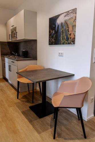 a kitchen with a table and two chairs at Heufeldboardinghouse in Kelheim