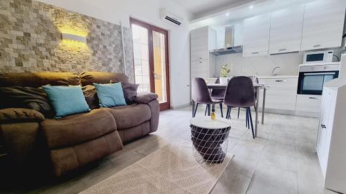 a living room with a brown couch and a table at Relax House - vicino al centro, lontano dal caos in Casalnuovo di Napoli