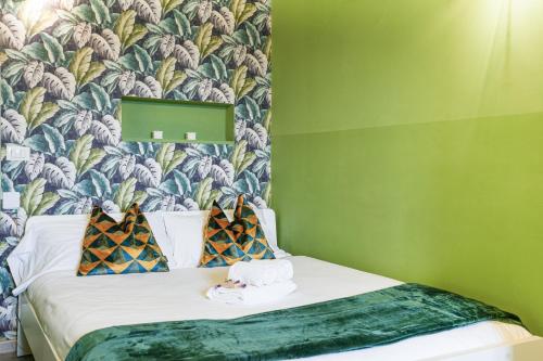 ein Schlafzimmer mit einem Bett mit einer grünen Wand in der Unterkunft Smeralda Attic Room in Turin