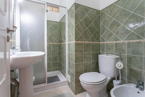 a bathroom with a toilet and a sink and a shower at Blife Faya private rooms in Faro