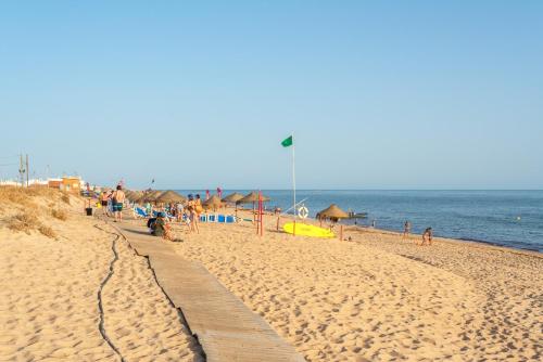 a beach with people on it and the ocean at Blife Faya private rooms in Faro