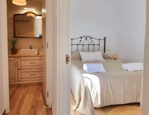 a bedroom with a bed and a bathroom with a sink at Perla Vera - Country Modern Apartment in Villanueva de la Vera