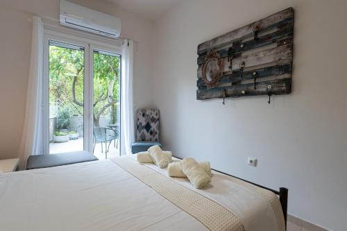 - une chambre avec un lit doté de draps blancs et une fenêtre dans l'établissement Sea Villa, à Akrogiali