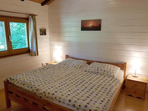 SteinbergにあるGemuetliches Blockhausのベッドルーム1室(ベッド1台、テーブルにランプ2つ付)