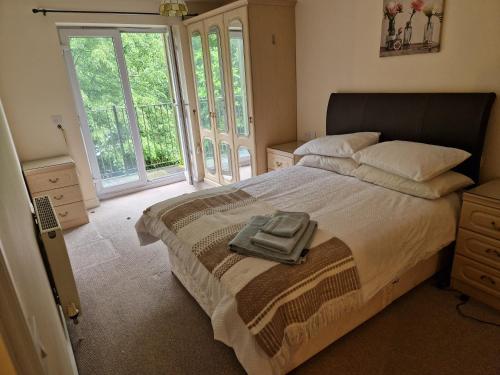 a bedroom with a large bed with a large window at 2 Bed Flat - Sleeps 4 - Parking - Wifi in Southampton