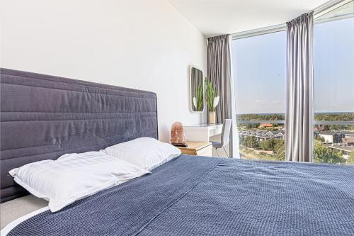 a bedroom with a large bed and a large window at ToVa Apartamentai in Palanga