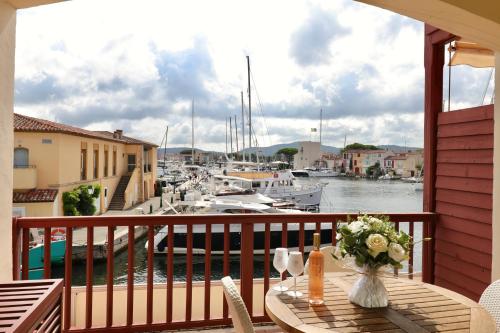 a balcony with a table with a view of a marina at Le Suffren Hôtel in Grimaud